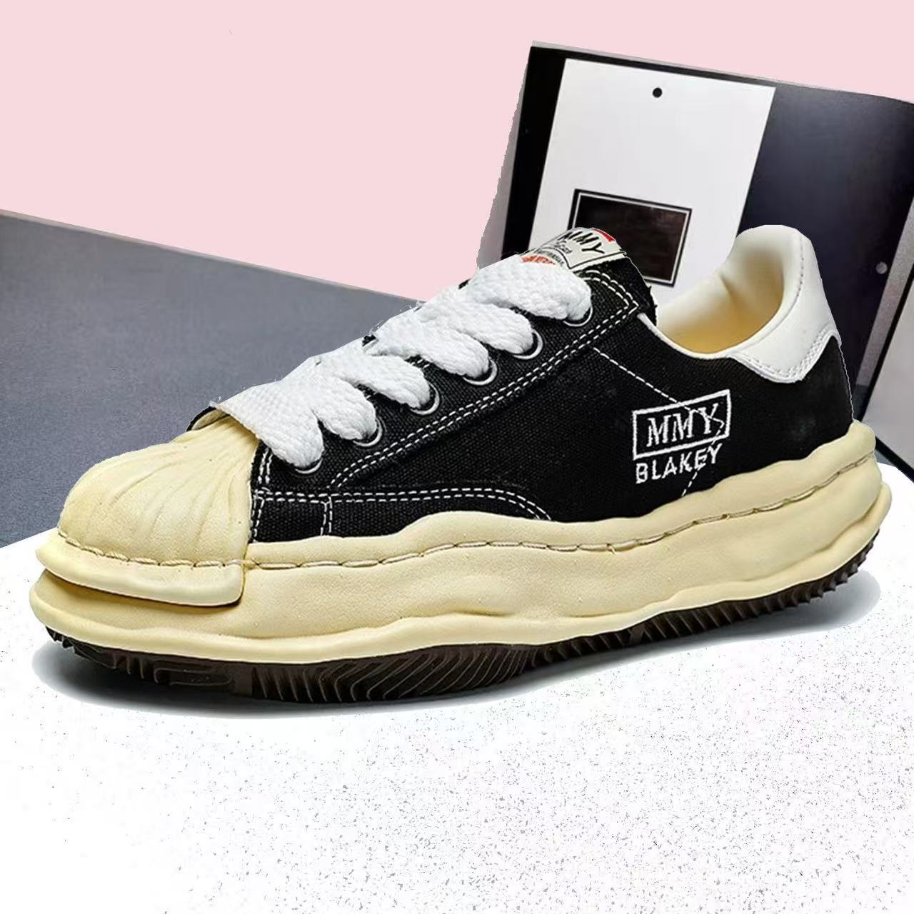 Mihara Yasuhiro black low-top sneakers with yellowed toe and sole